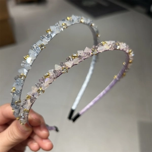 Détail macro du serre-tête en cristal scintillant avec strass bleu argenté et violets