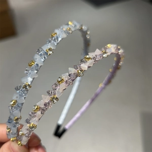 Gros plan de serre-têtes en cristal bleu et violet avec ruban de soie et détails dorés