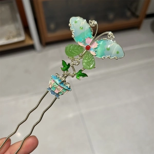 Detailed close-up of a vintage butterfly hair fork with colorful enamel and floral elements