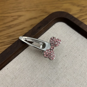 Makrodetail einer eleganten silbernen Haarspange mit einer rosa Strassschleife für Mädchen