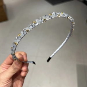 Serre-tête élégant en cristal avec pierres strass et perles sur un bandeau fin argenté