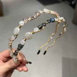 Detail of handmade thin gold headband with crystal beads and white faux pearls decoration