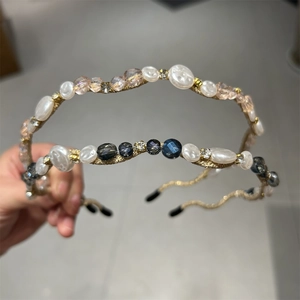 Detail of wavy gold metal headbands featuring delicate white pearls and crystal beadwork