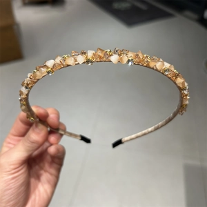 Détail du serre-tête en cristal champagne orné de strass et perles à la main
