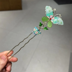 Detailed shot of an ancient Chinese style U-shaped butterfly hair fork with enamel colors