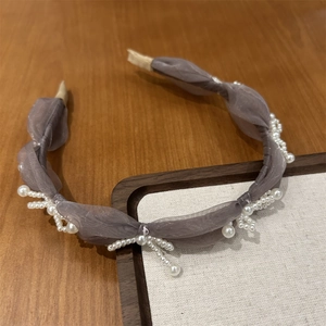 Detailed view of elegant organza pleated headband with clustered pearl accents and padding