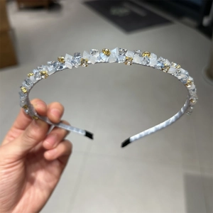 Détail d'un serre-tête de luxe avec cristaux bleu clair et accents en métal doré