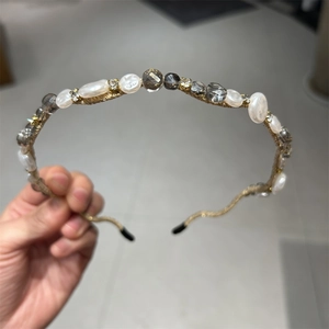 Close-up of a handmade beaded headband featuring crystal beads and irregular white pearls