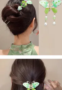 Detail view of the green butterfly hair pin set with elegant pearls and tassels