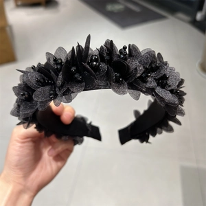 Detailansicht eines handgefertigten schwarzen Blumenhaarreifs mit 3D-Perlen und Kristallen