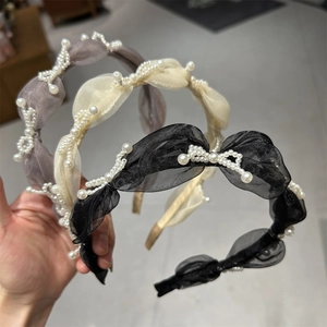 Detailed view of organza headbands with wave pearl embellishments in three colors