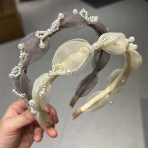 Detail of organza headband with delicate pearl embellishments in soft lavender and beige