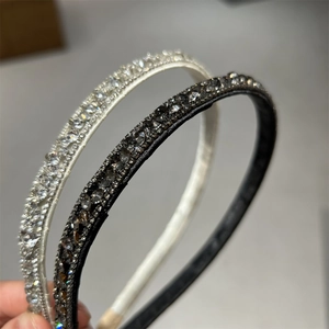 Close-up of sparkling rhinestones on elegant thin headband in black and white finish