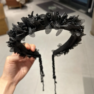 Detailansicht des handgefertigten schwarzen Blumen-Stirnbands mit eleganten Kristall-Quasten