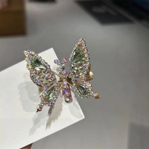 Dettaglio del fermaglio per capelli a farfalla mobile con strass colorati e gemme verdi