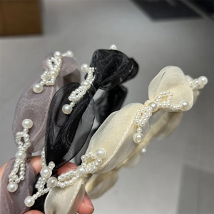 Detail of organza bow headbands with faux pearls in black, cream, and lavender gray colors