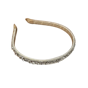 Elegant rhinestone headband with shimmering crystals and luxury champagne fabric finish