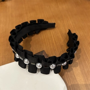 Vue détaillée du serre-tête en satin plissé noir orné de perles et de strass brillants