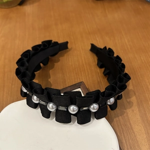 Détail d'un serre-tête en satin plissé avec perles blanches et cristaux rectangulaires