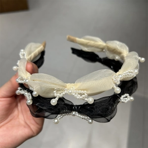 Detailed view of handmade organza bow headbands with intricate white pearl embellishments