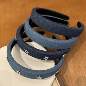 Detail of four denim headbands with silver star zircons on a white display tray