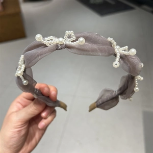 Detail of grey organza headband with white pearls and twisted fabric texture