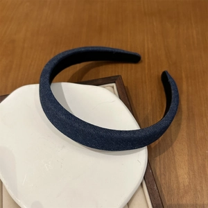 Detailed view of dark blue denim headband texture with non-slip lining on display