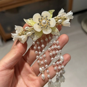 Detail der Vintage-Haarklammer mit Maiglöckchen, Perlenquasten und Blumenmuster