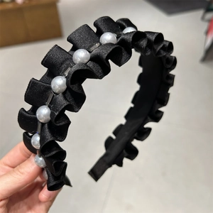 Serre-tête en satin noir plissé orné de perles et cristaux élégants tenu à la main