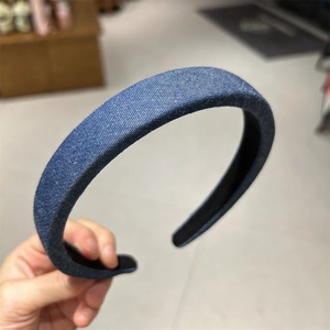 Close-up of dark blue denim fabric texture and thick padded structure of the headband