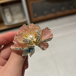 Vue détaillée d'une broche pivoine rose avec émail, perle et cristaux brillants
