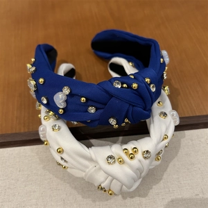 Détail du bandeau torsadé avec strass en forme de cœur et ornements en perles