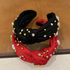 Gros plan de serre-têtes noués en rouge et noir avec perles dorées et strass brillants