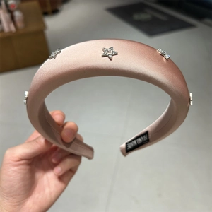 Dettaglio cerchietto in raso rosa chiaro con stelle di strass e etichetta fatta a mano