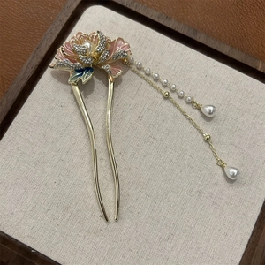 Détail macro d'une épingle à cheveux pivoine vintage avec glands en perles roses