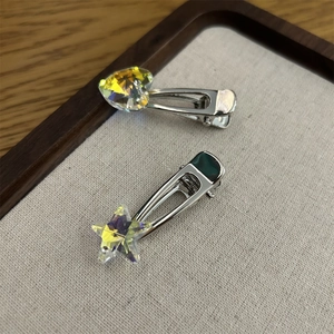 Nahaufnahme von glitzernden Herz- und Stern-Haarspangen mit polierter Silber-Metallbasis