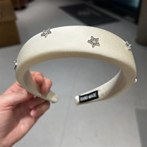 Dettaglio del cerchietto in raso bianco con stelle di strass e l'etichetta fatta a mano
