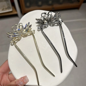 Detailed close-up of gold and silver swan hair pins with sparkling crystals