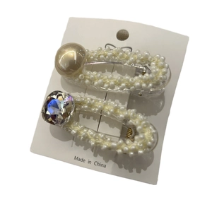Elegante set da due pezzi di fermagli per capelli con perle dorate e cristalli su carta