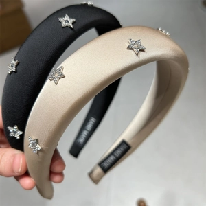 Dettaglio di cerchietti imbottiti fatti a mano con stelle di strass in nero e champagne