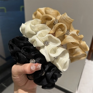 Detailed close-up of organza hair scrunchies with elegant floral rhinestone embellishments
