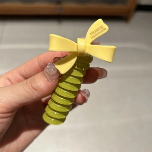 Green spiral hair ring with yellow handmade bow for high ponytail styling