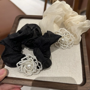 Detail of camellia hair scrunchies with pearls in black and cream chiffon fabric