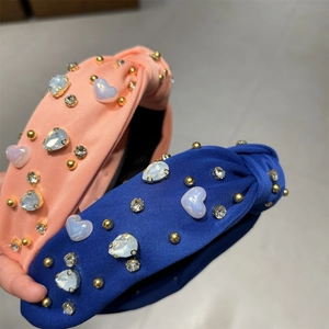 Détail de serre-tête noué avec pierres en cœur, strass et perles sur tissu