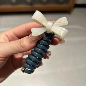 Japanese style telephone wire hair tie with a white iridescent pearl bow and gold text