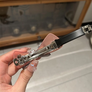 Detail of pink acetate bow hair clip featuring a durable silver metal spring fastener