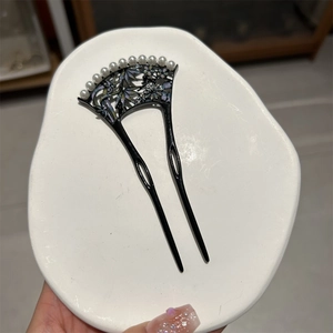 Détail de l'épingle à cheveux en forme d'éventail avec nacre et onze perles sur métal noir