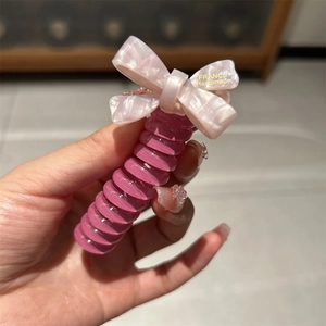 Pink marble acetate spiral hair tie with a handmade bow for high ponytail styling