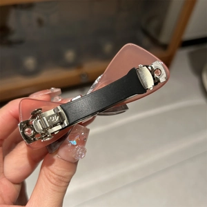 Detail of pink acetate bow hair clip with sturdy black spring metal fastener mechanism