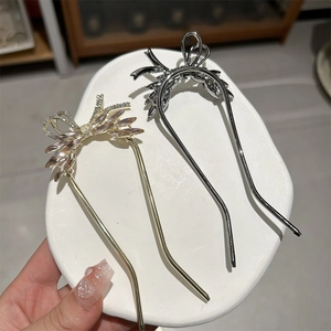 Detail of elegant bow hairpins featuring sparkling zircons in gold and silver finishes